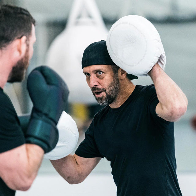 Coach to UFC fighters, Jason Parillo , holding punching mitts for Michael Bisping